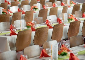 Long Tables With White Cloths and Brown Chairs Formal Setting